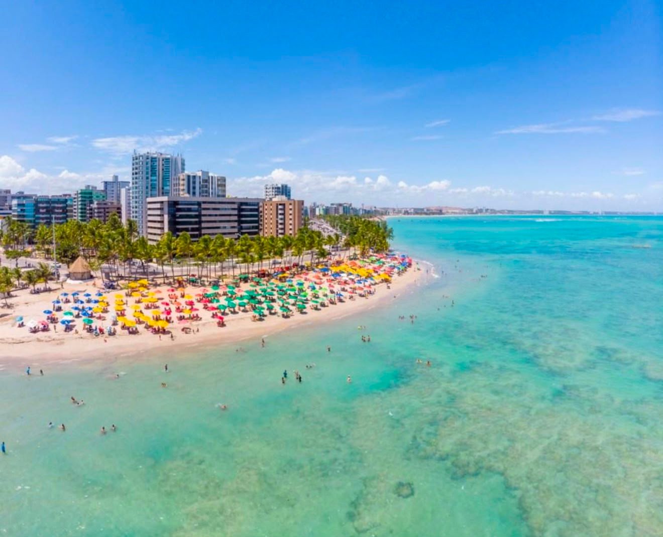 Praia de Maceió com guarda-sóis e mar transparente